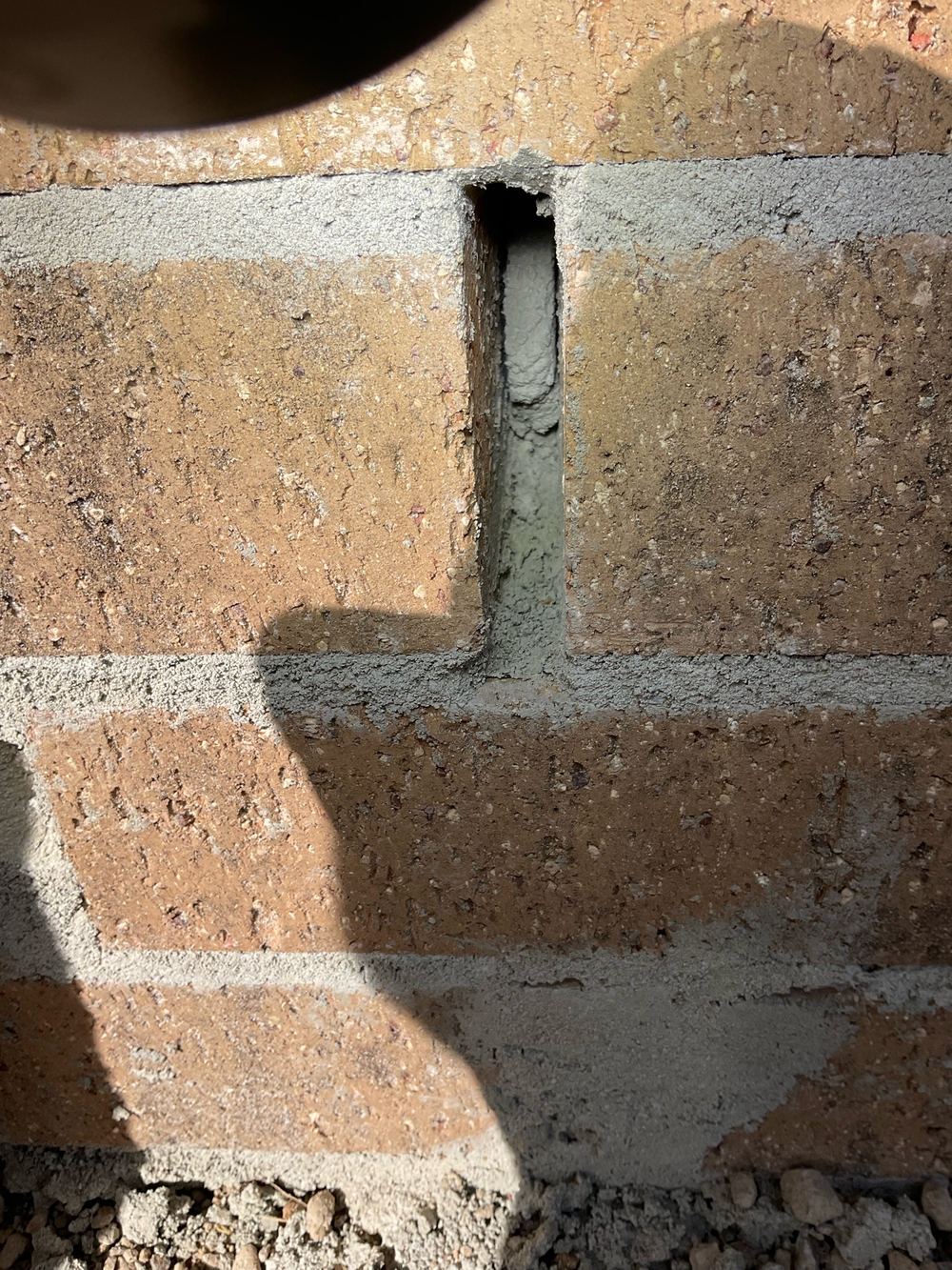 Weep holes packed with mortar, so the wall cavity cannot drain or breathe, found during a lock-up inspection in Truganina