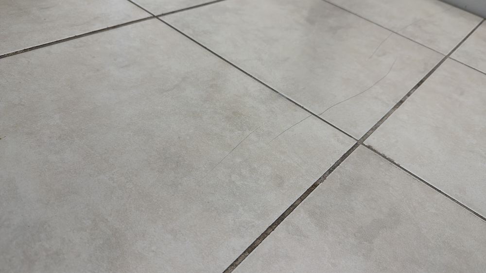 Cracked floor tile that needs replacing before it lets water through, found during a pre-purchase inspection in Deer Park