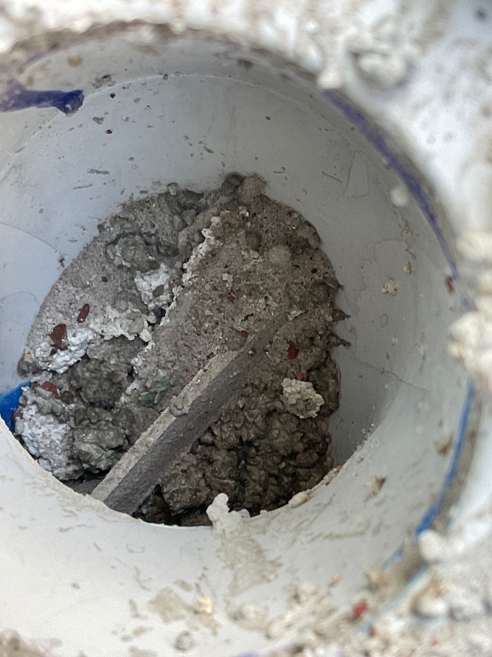 Cement left in a wet area drain where it will set and cause a blockage, found during a waterproofing inspection in Truganina